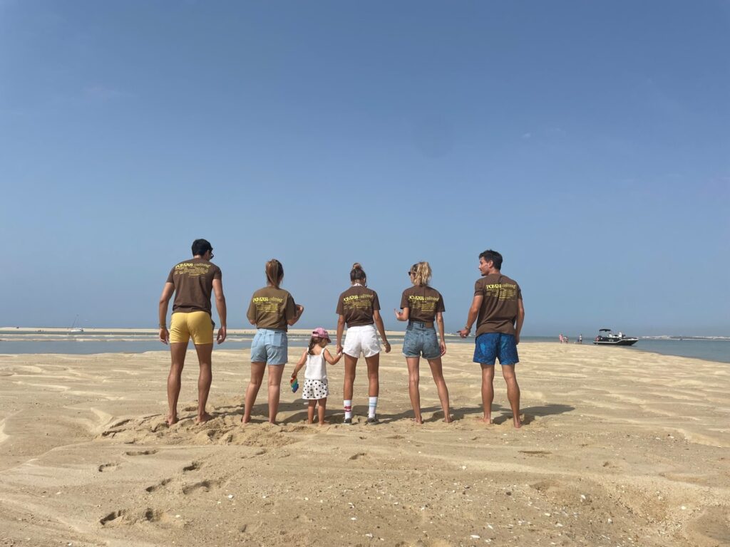 group of colivers seen from behind at the beach near POMAR Coliving in Algarve, Portugal