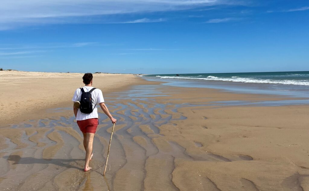 A man walking on the beach of Ria Formosa's islands - POMAR coliving