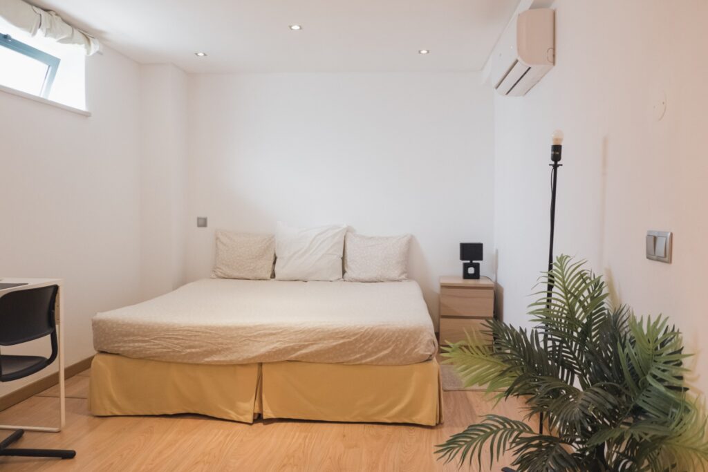 View of the bed of the standard bedroom with private bathroom at POMAR coliving in Portugal.