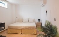 View of the bed of the standard bedroom with private bathroom at POMAR coliving in Portugal.