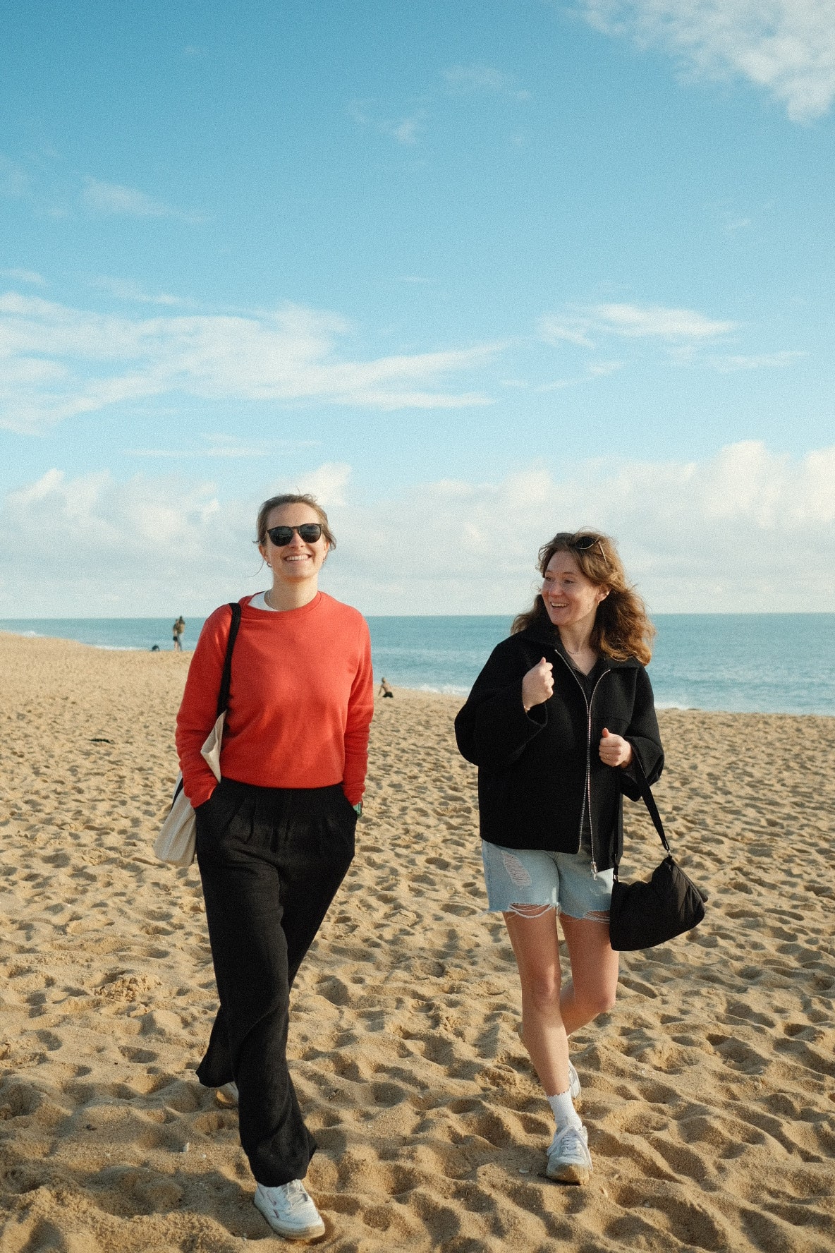 Anja, coliver at POMAR Coliving, walking along Praia de Faro beach with her friend in Algarve, Portugal