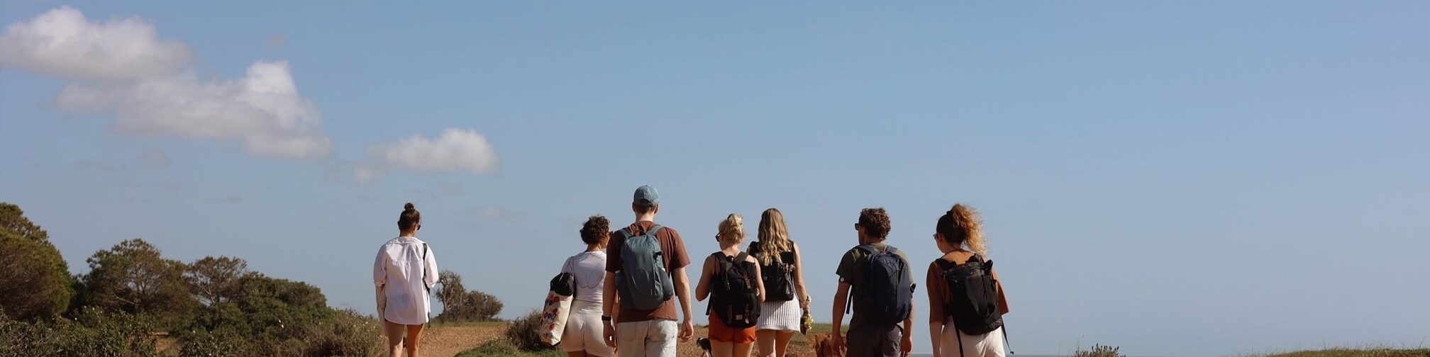 A group of coliver hiking on a trail near the beaches of POMAR coliving in Portugal.