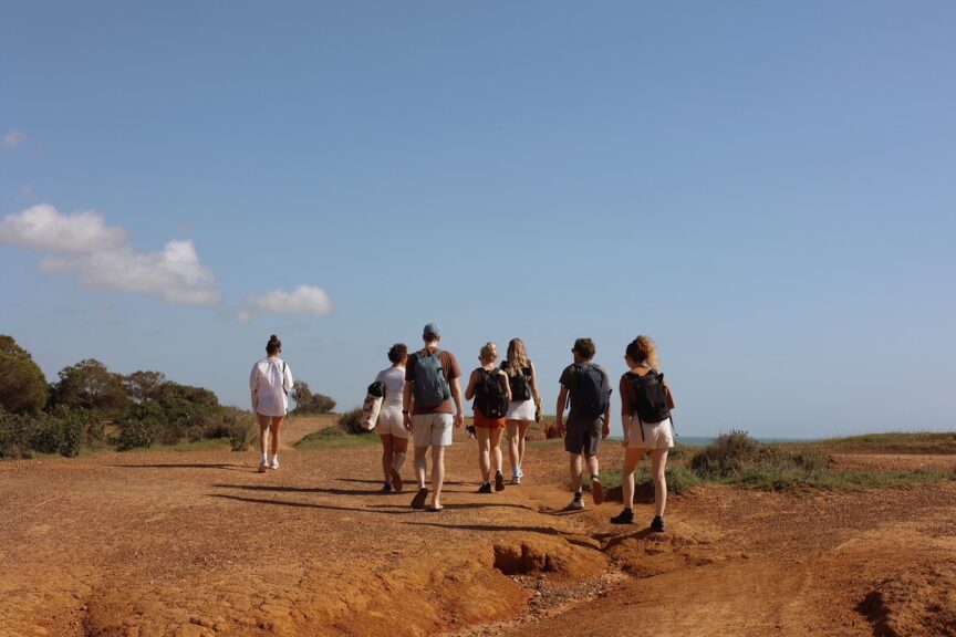 A group of coliver hiking on a trail near the beaches of POMAR coliving in Portugal.