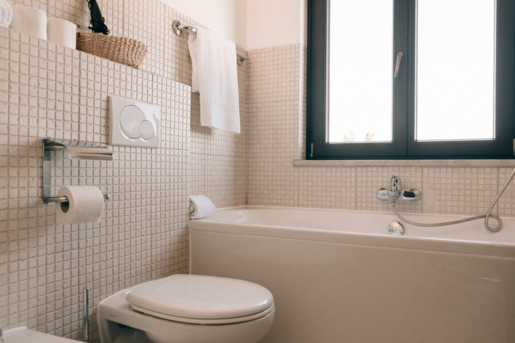 Bright and modern bathroom with a bathtub, tiled walls, and window at POMAR na praia.