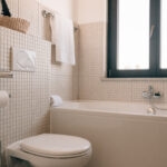 Bright and modern bathroom with a bathtub, tiled walls, and window at POMAR na praia.