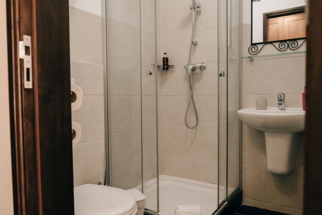 Modern private bathroom in the suite at POMAR na praia, with walk-in shower, sink, and minimalist decor.