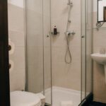Modern private bathroom in the suite at POMAR na praia, with walk-in shower, sink, and minimalist decor.