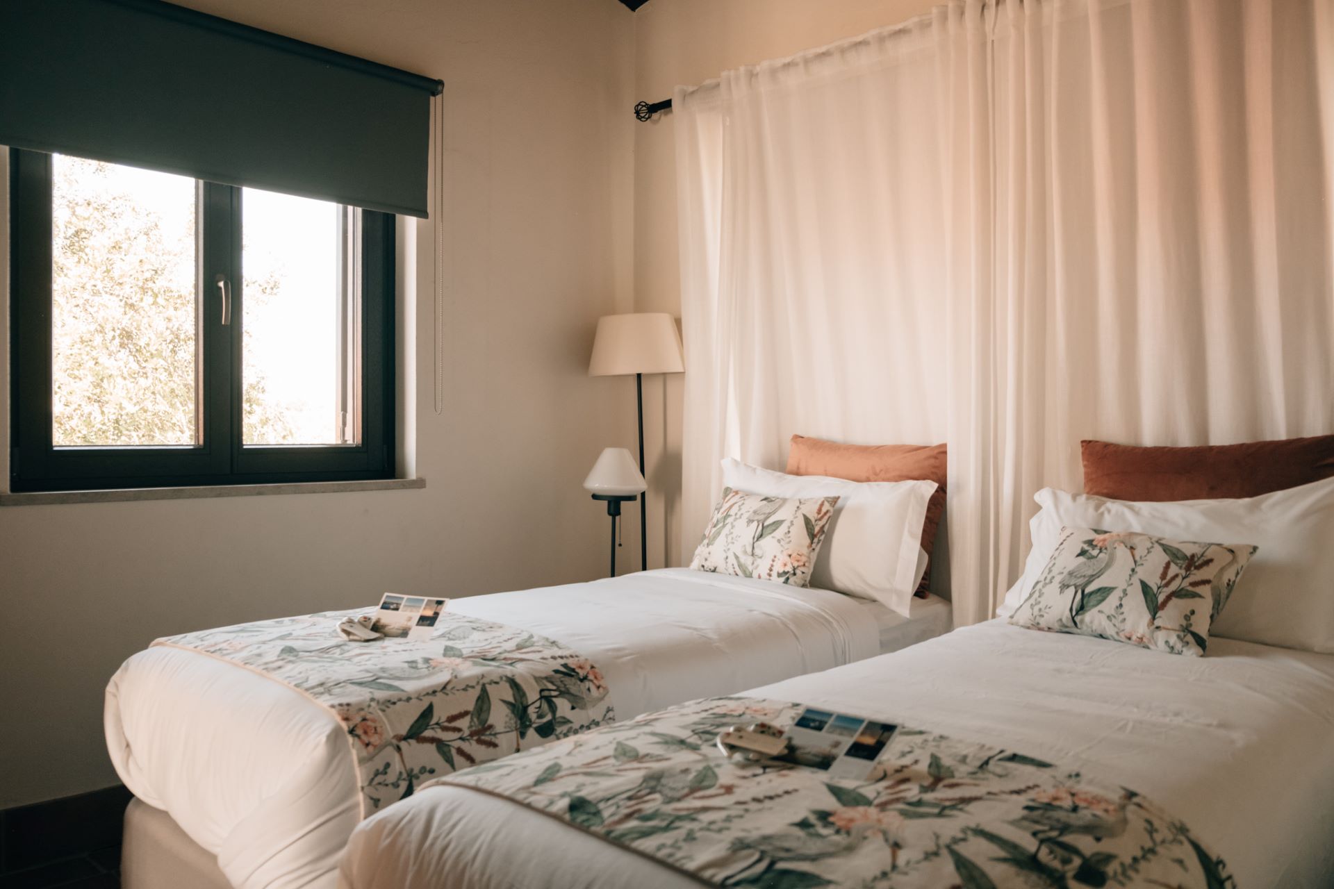 dorm bed – POMAR na praia Bright dorm-style room at POMAR na praia with two single beds, floral decor, and soft lighting