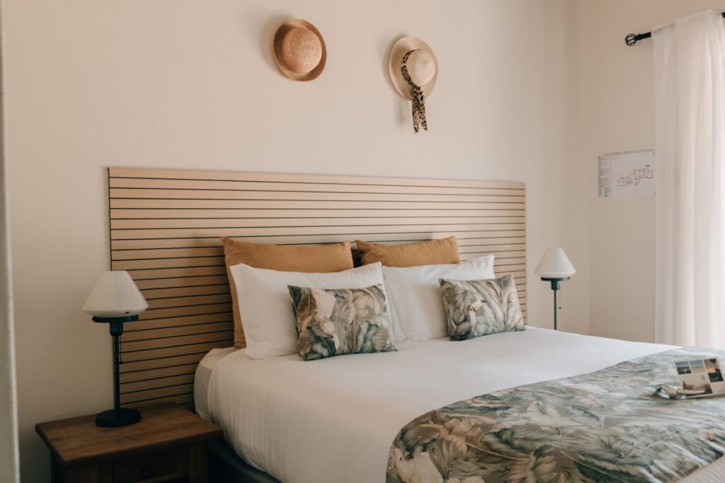 tylish suite bedroom at POMAR na praia with queen-size bed, natural tones, and decorative pillows.