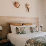 tylish suite bedroom at POMAR na praia with queen-size bed, natural tones, and decorative pillows.