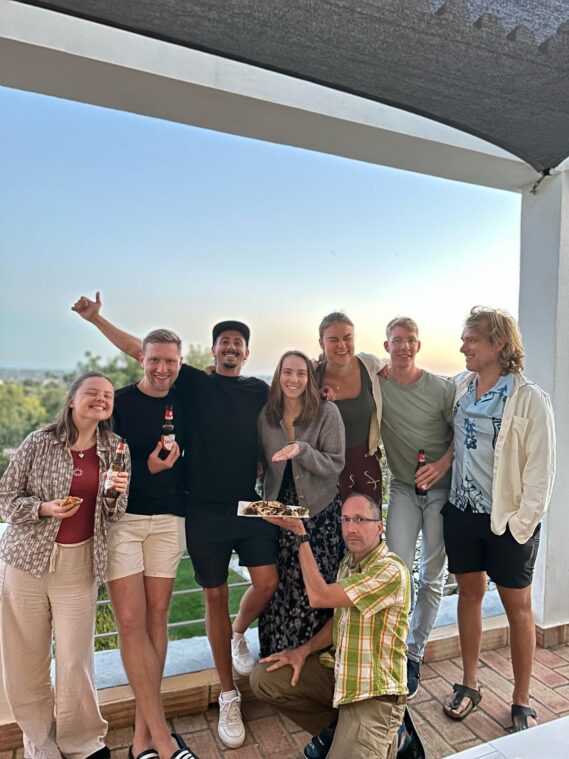Colivers sharing drinks and snacks during golden hour on a terrace