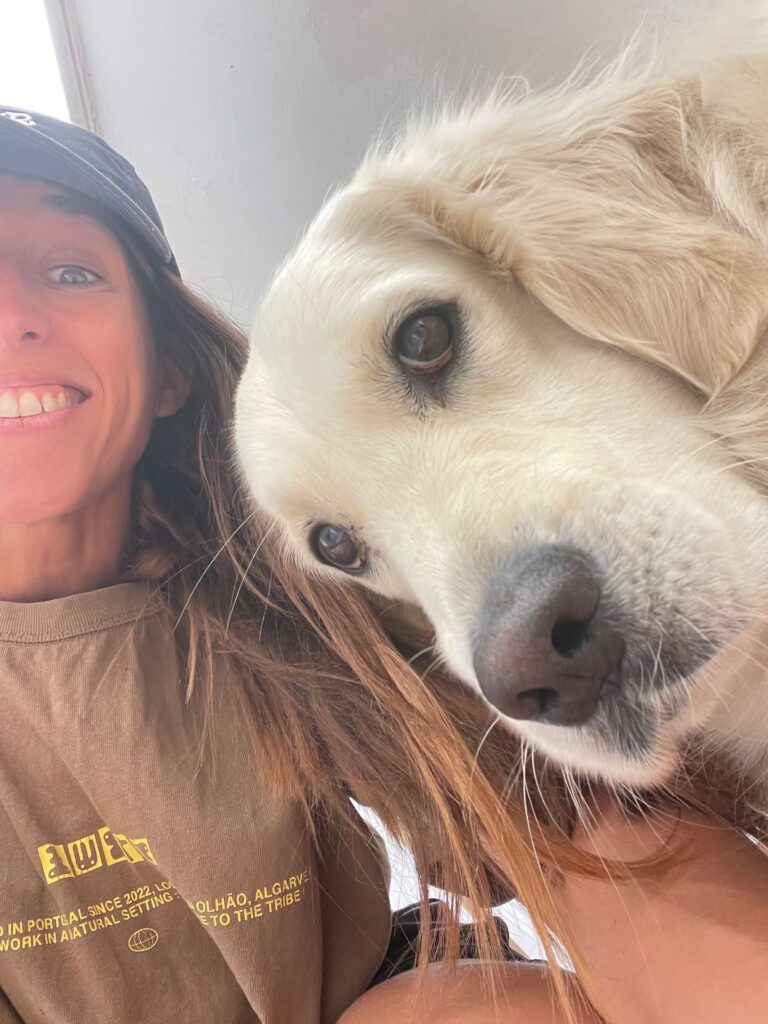 Claire, co-founder of POMAR, smiling with Nala the golden retriever
