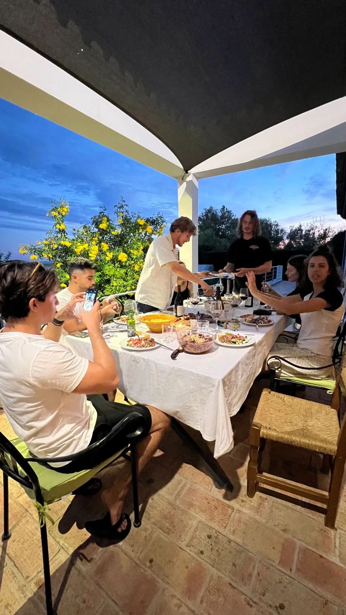 Colivers gathered at the long dinner table on the terrace, evening
