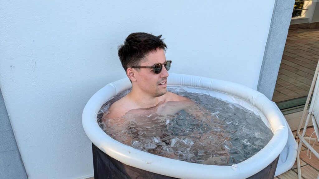 Man relaxing in an ice bath outdoors at POMAR Coliving