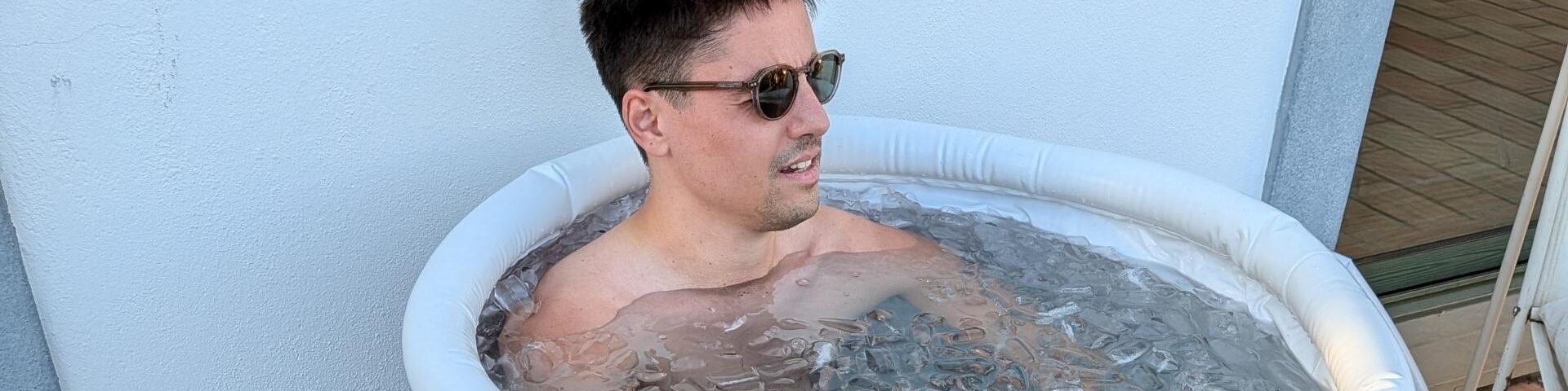 Cold exposure and recovery at POMAR Coliving Algarve Man relaxing in an ice bath outdoors at POMAR Coliving