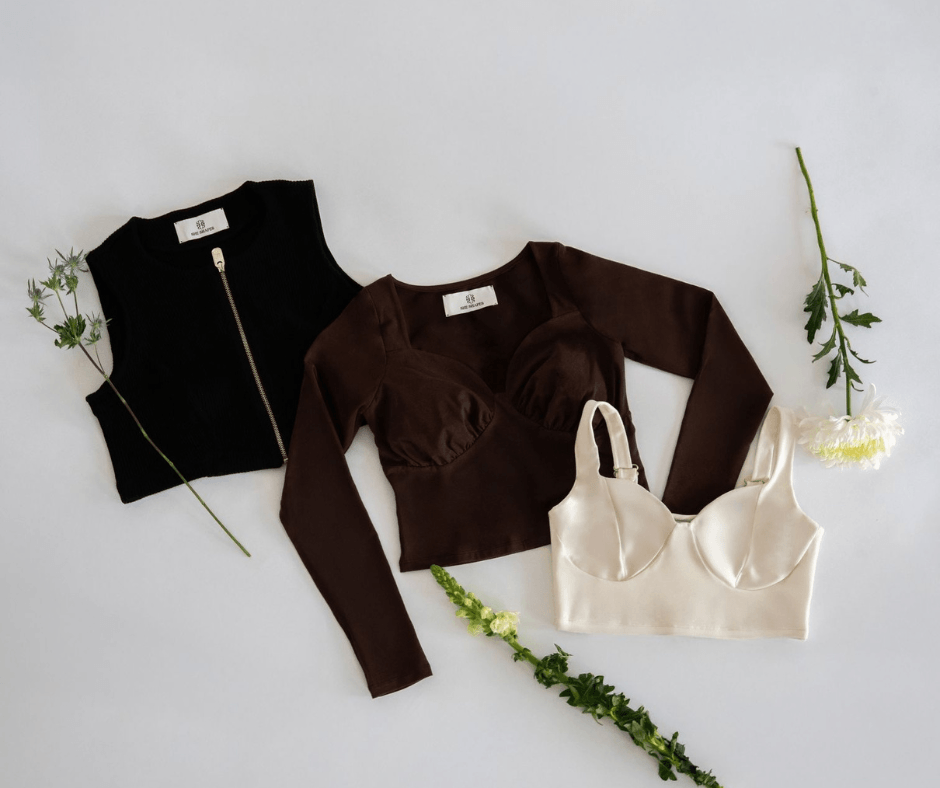 Minimal flat lay of sustainable clothing items arranged with natural elements
